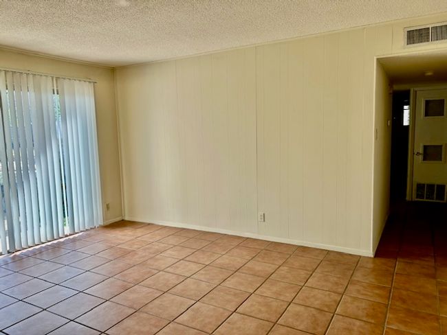 Empty room with visible vents, a textured ceiling, and light tile patterned floors | Image 4