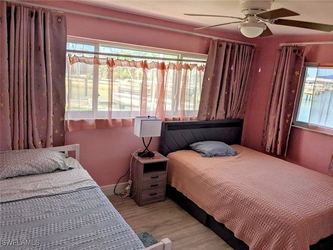 Bedroom with baseboards, ceiling fan, and wood finished floors | Image 31