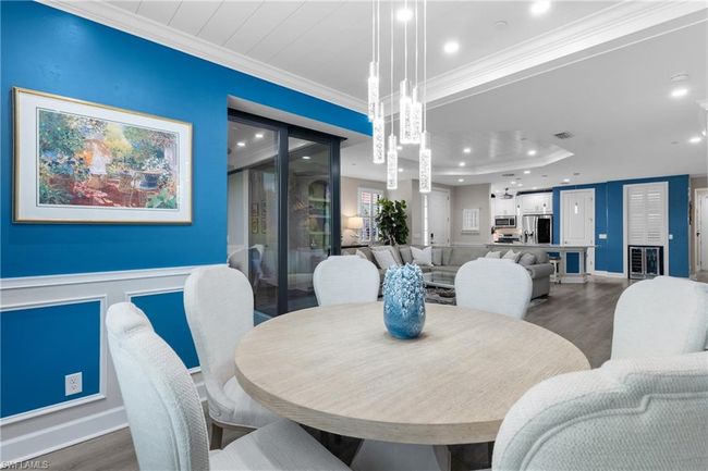 Dining space featuring crown molding, wood finished floors, recessed lighting, wine cooler, and a wainscoted wall | Image 12