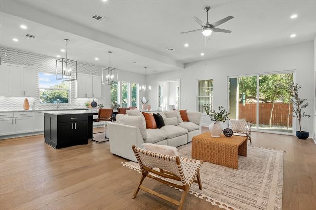 Living area with ceiling fan with notable chandelier, visible vents, recessed lighting, and light wood-style floors | Image 5