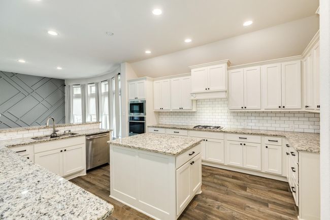 spacious kitchen with its granite counter tops, plenty of cabinets, and huge island. | Image 16