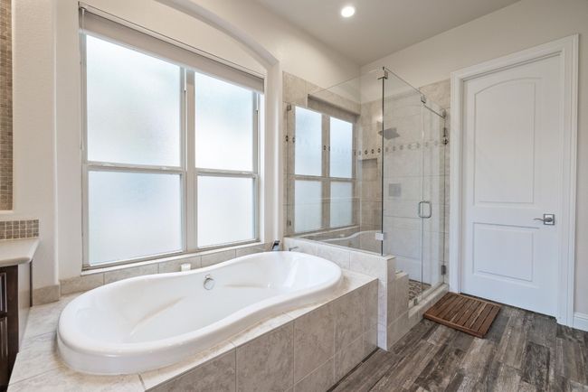 Bathroom with a bath, a stall shower, healthy amount of natural light, wood finished floors, and recessed lighting | Image 19
