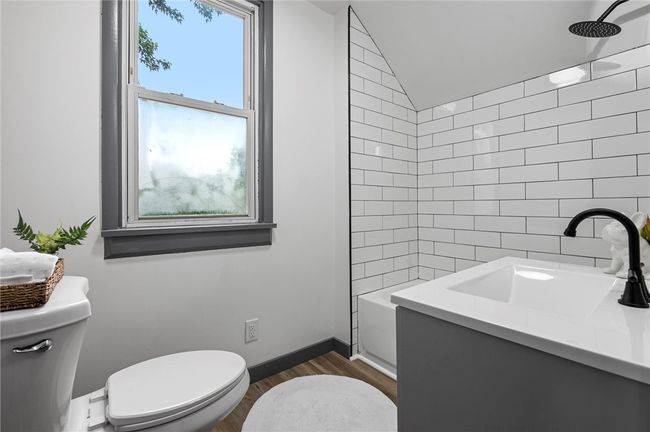 A beautifully renovated bathroom adds a touch of luxury with updated tile, vanity, and hardware. | Image 17