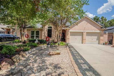 Gorgeous 1.5 story brick home featuring a well-manicured front yard with mature trees, decorative landscaping, and a two-car garage, set in a pleasant neighborhood. | Image 2