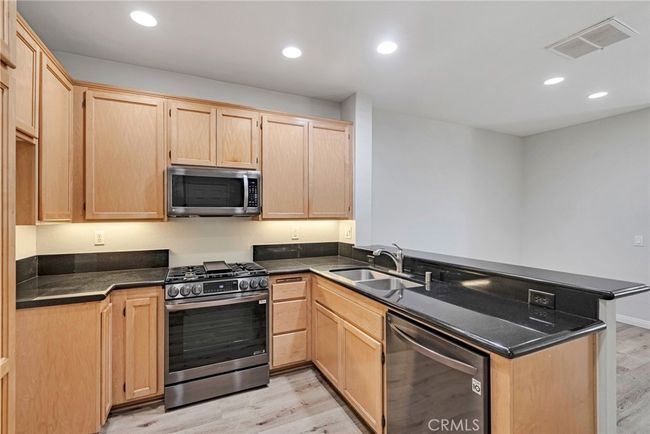 KITCHEN WITH STAINLESS APPLIANCES, BREAKFAST BAR AND PANTRY | Image 13