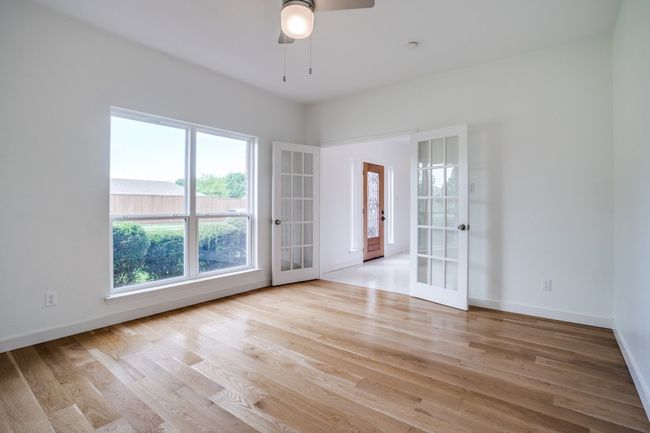 Spare room featuring french doors, ceiling fan, wood finished floors, and baseboards | Image 5