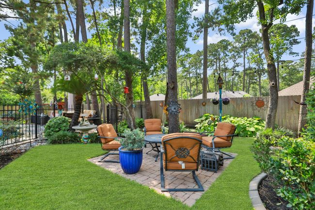 Charming brick paver seating area surrounded by lush grass and mature trees creates a peaceful outdoor retreat perfect for relaxation and entertaining. | Image 28