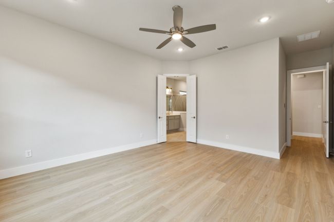 Unfurnished bedroom featuring light wood finished floors, recessed lighting, ensuite bathroom, and ceiling fan | Image 16