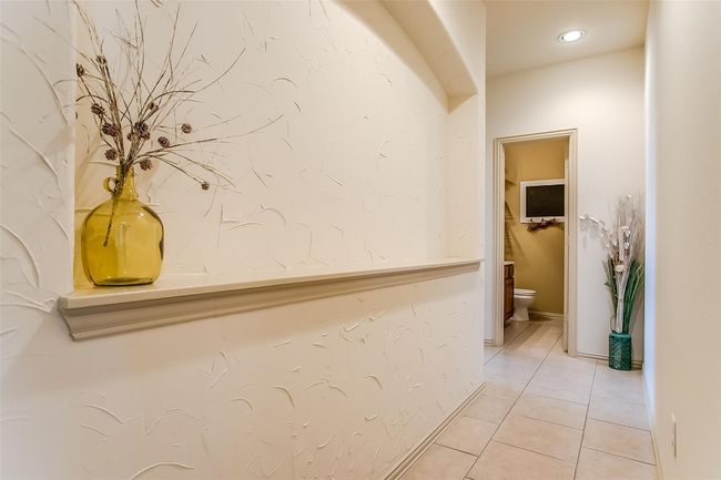 Hallway with light tile patterned flooring & declarative ledge. | Image 6