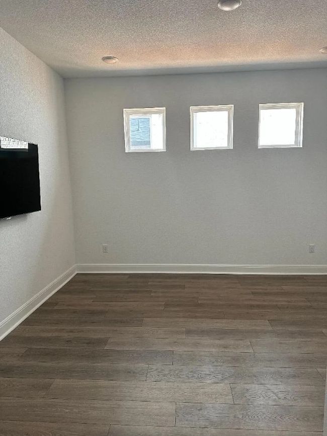 Unfurnished room featuring wood finished floors and plenty of natural light | Image 11