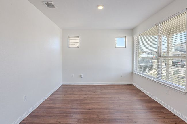 Unfurnished room featuring plenty of natural light, dark wood-type flooring, baseboards, and visible vents | Image 16