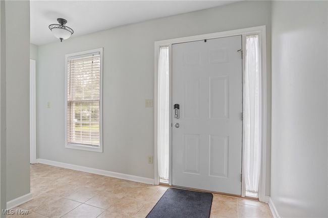 Entryway featuring light tile patterned floors and baseboards | Image 4