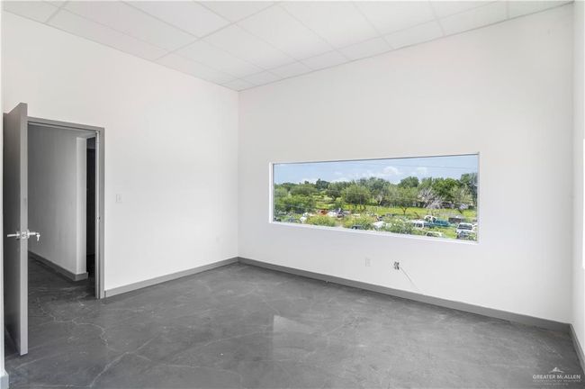 Empty room featuring baseboards, concrete flooring, and a drop ceiling | Image 31