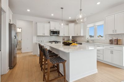 (*Photo of decorated model, actual homes colors and finishes will vary) Enjoy this spacious gourmet kitchen with stylish finishes and a large kitchen island to accommodate seating | Image 2