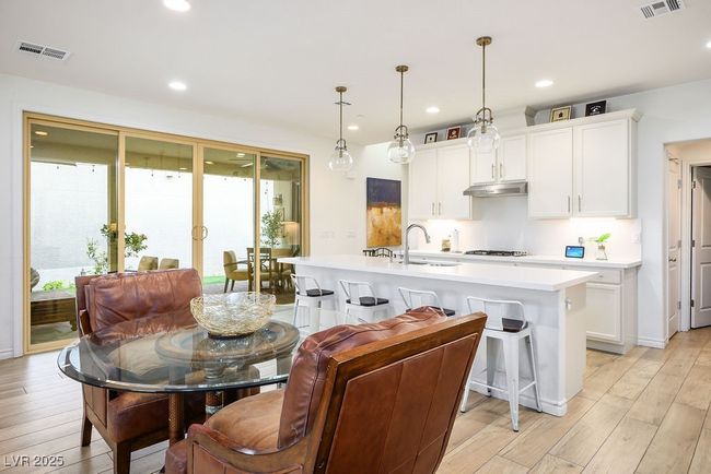 Kitchen featuring visible vents, under cabinet range hood, light countertops, and a sink | Image 14