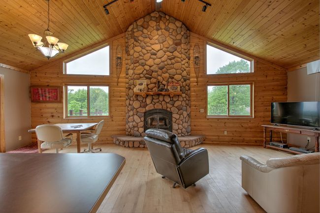 Floor to ceiling pre-cast bolder stone wood fireplace with hearth and 1/2 log mantel. | Image 8