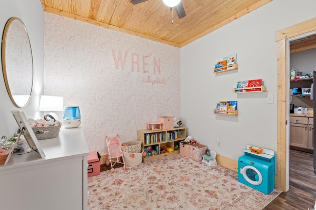 Game room with wood ceiling, a ceiling fan, wood finished floors, and wallpapered walls | Image 34