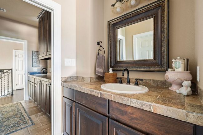 Bathroom featuring stone tile floors, vanity | Image 32