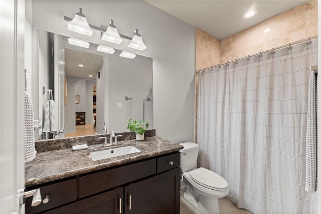 A well-appointed full bath serves the two secondary bedrooms, featuring refined finishes, a spacious vanity, and a tub/shower combination... | Image 33