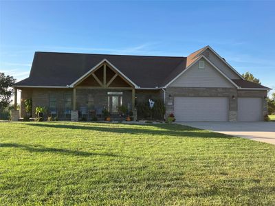 View of front of house with a front lawn, a porch, and a garage | Image 1