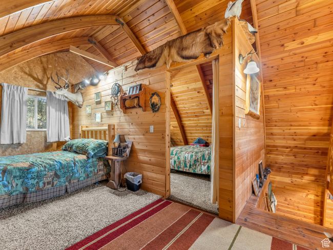 Carpeted bedroom with wood walls and wood ceiling | Image 21