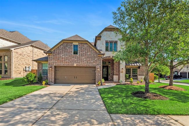 Gorgeous elevation with brick and stone, mature trees and OVERSIZED 2 CAR GARAGE. | Image 4