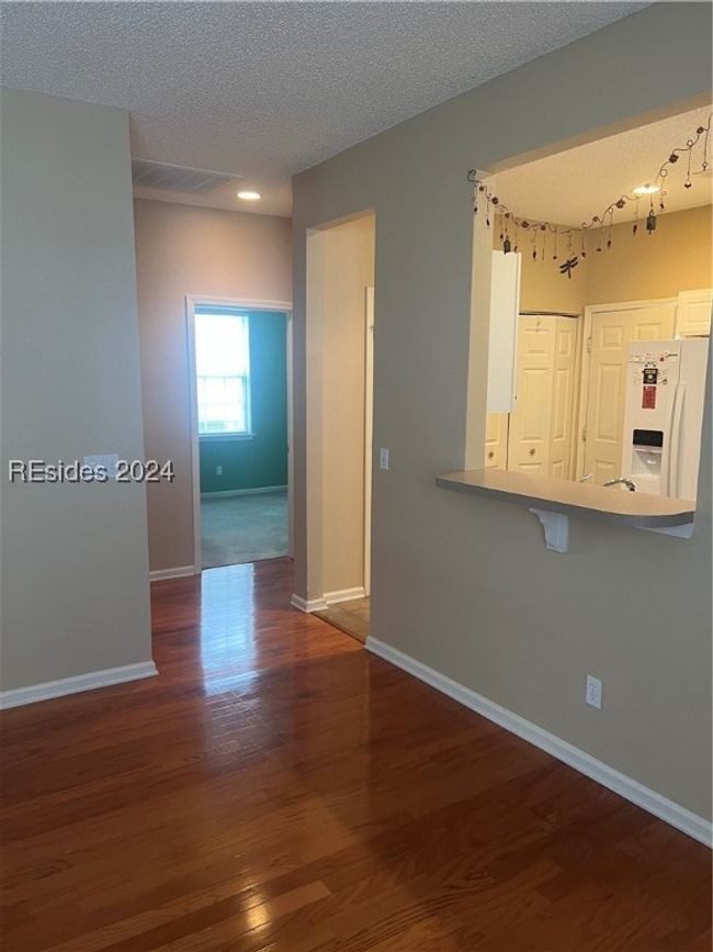 Unfurnished living room with dark hardwood / wood-style flooring and a textured ceiling | Image 11