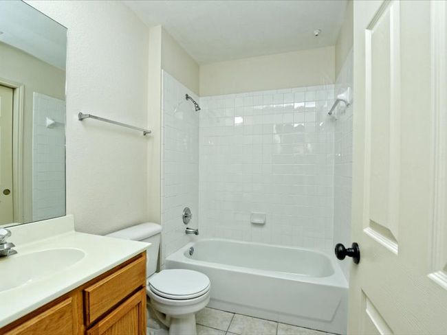 Full bathroom with shower combination, toilet, tile patterned flooring, and vanity | Image 22