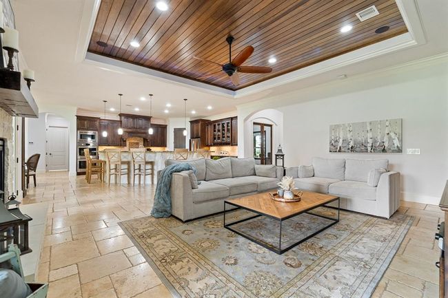 Notice how the Traveterine flooring traverses the entire living area. With an open concept design like this, it is important to have consistencies that tie the different spaces together. | Image 12