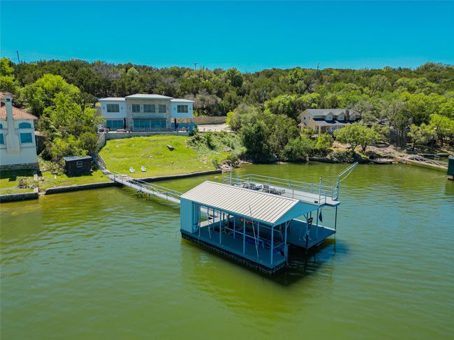 Dock area featuring a water view, boat lift, and a forest view | Image 4