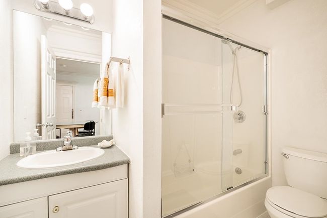 Full bathroom featuring ornamental molding, vanity, and enclosed tub / shower combo | Image 26