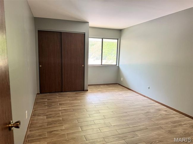 Unfurnished bedroom with light wood-style flooring and a closet | Image 16