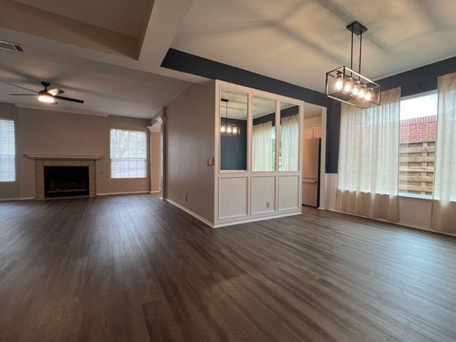 Unfurnished living room featuring a fireplace, dark wood finished floors, and a ceiling fan | Image 39