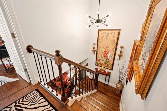 Staircase with wood finished floors and a chandelier | Image 19