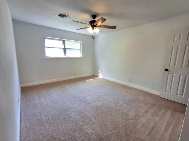 Spare room with a ceiling fan, baseboards, and carpet | Image 16