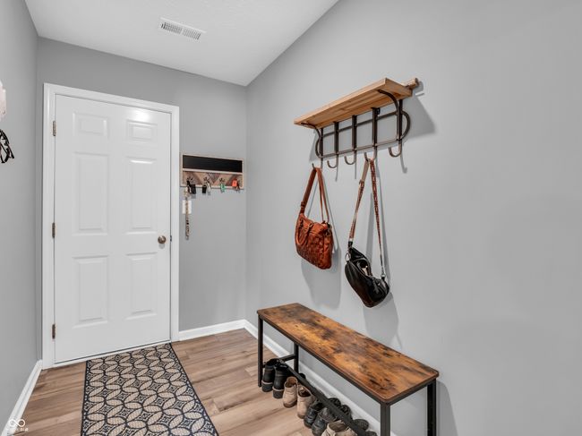 interior space featuring visible vents, light wood finished floors, and baseboards | Image 19