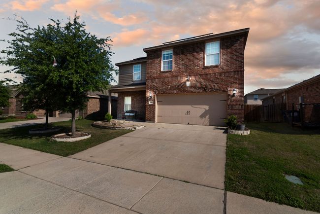 Traditional home with driveway, fence, brick siding, a garage, and a yard | Image 4