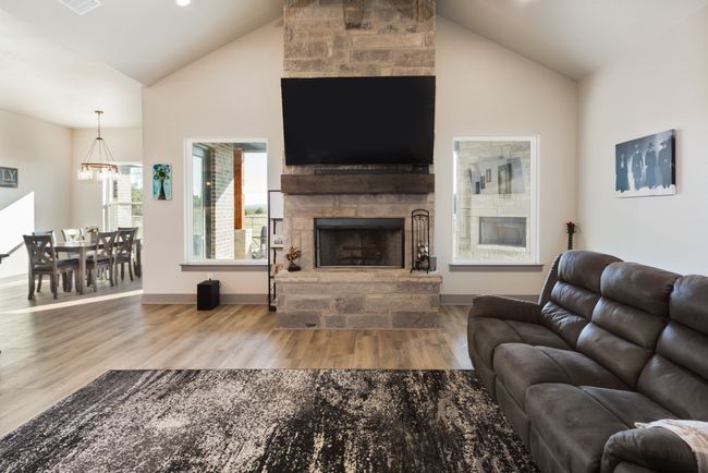 Living room with a stone fireplace, wood finished floors, baseboards, high vaulted ceiling, and a​​‌​​​​‌​​‌‌​‌‌​​​‌‌​​‌‌​‌​​​​​‌ chandelier | Image 18
