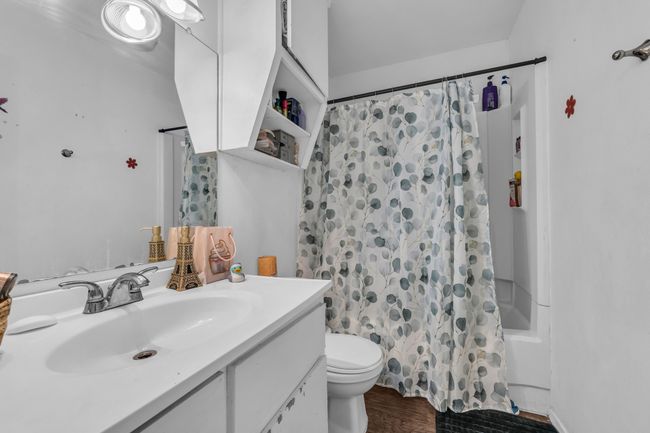 Bathroom featuring vanity, shower / tub combo, and wood finished floors | Image 15