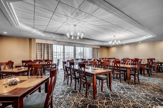 Carpeted dining room with a raised ceiling and a notable chandelier | Image 33