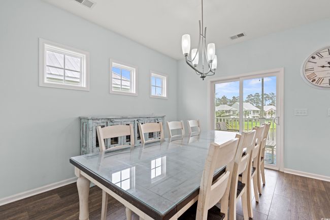 Dining area featuring many windows and an open concept. The upper deck is off of the dining area with pond view. | Image 19