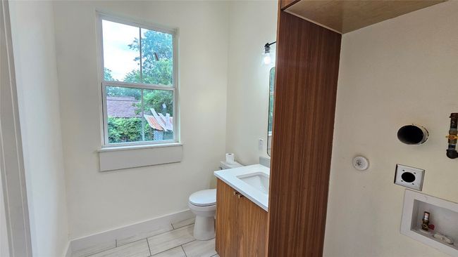 Half bath featuring toilet, vanity, healthy amount of natural light, and baseboards | Image 8