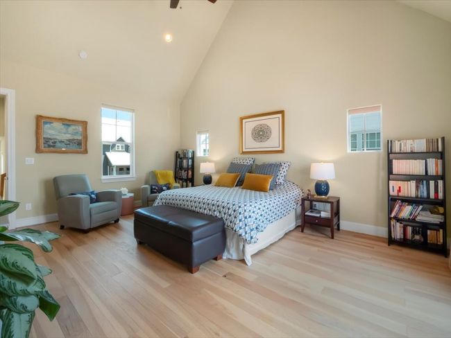 Bedroom with high vaulted ceiling, wood finished floors, and baseboards | Image 9