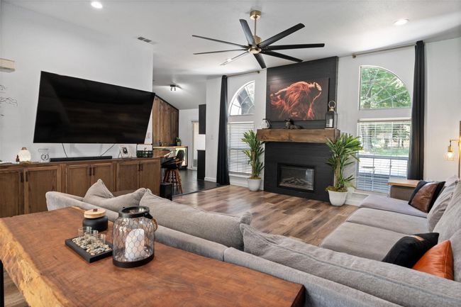 Living room featuring hardwood / wood-style flooring, a large fireplace, and ceiling fan | Image 10