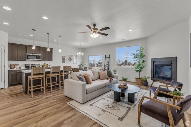 Living room with ceiling fan with notable chandelier and light hardwood / wood-style flooring | Image 6
