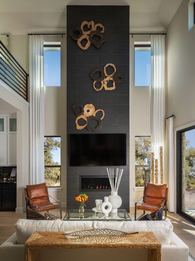 Living area featuring a towering ceiling, wood finished floors, a tiled fireplace, and plenty of natural light | Image 6
