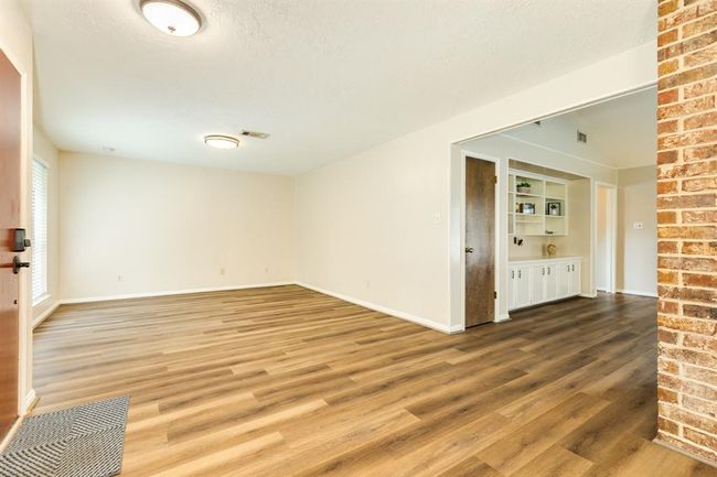 At the front of the home sits the formal living & dining room -- plenty of space to entertain family & friends. LVP throughout the living spaces of the home. Family room to the right of the photo with an expansive built in shelves ready for you to display all your treasures! | Image 9