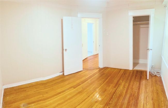 Unfurnished bedroom with light wood finished floors and a closet | Image 6