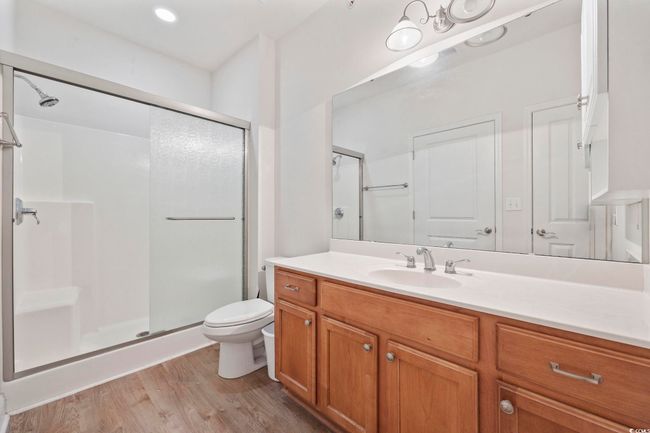 Full bath with a shower stall, toilet, vanity, and wood finished floors | Image 11