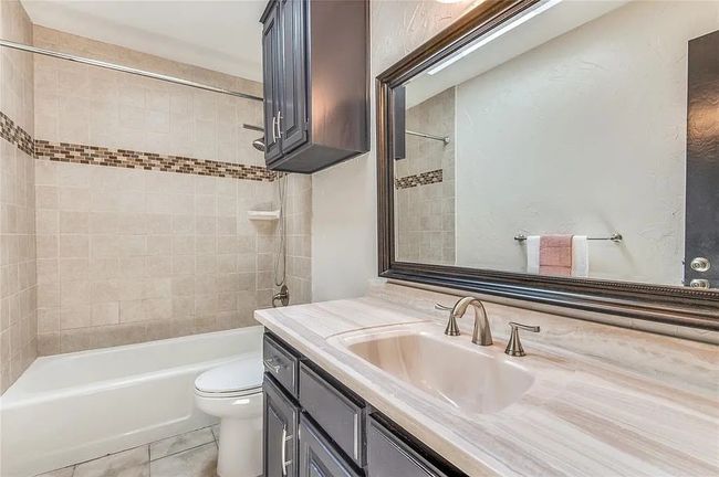 Full bathroom featuring shower / tub combination, vanity, toilet, and tile patterned floors | Image 20